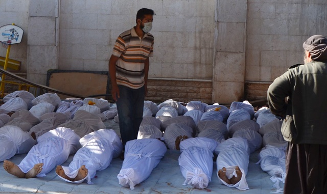 Ativistas sírios inspecionam corpos de vítimas de ataque com armas químicas que matou 1,4 mil civis em 2013